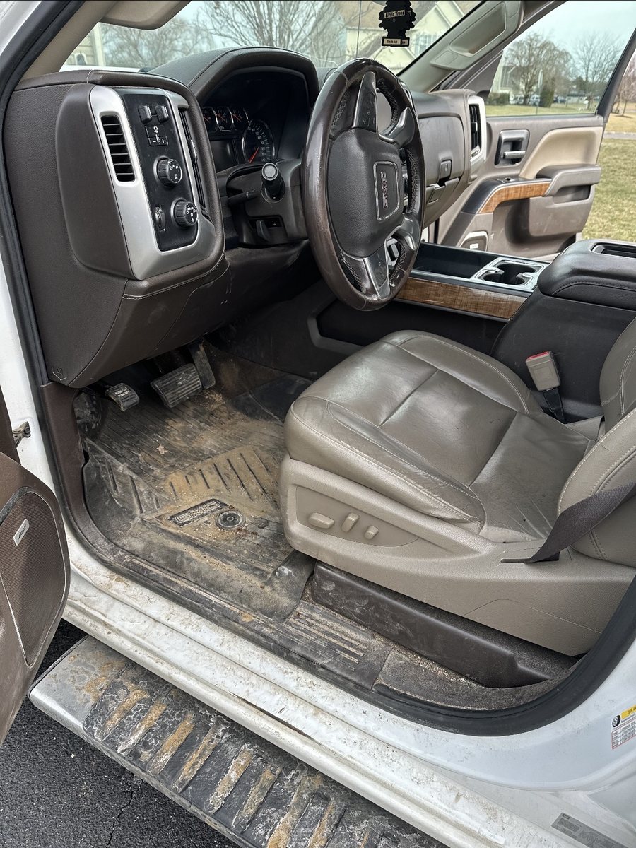 Dirty truck interior with muddy floor mats before detailing